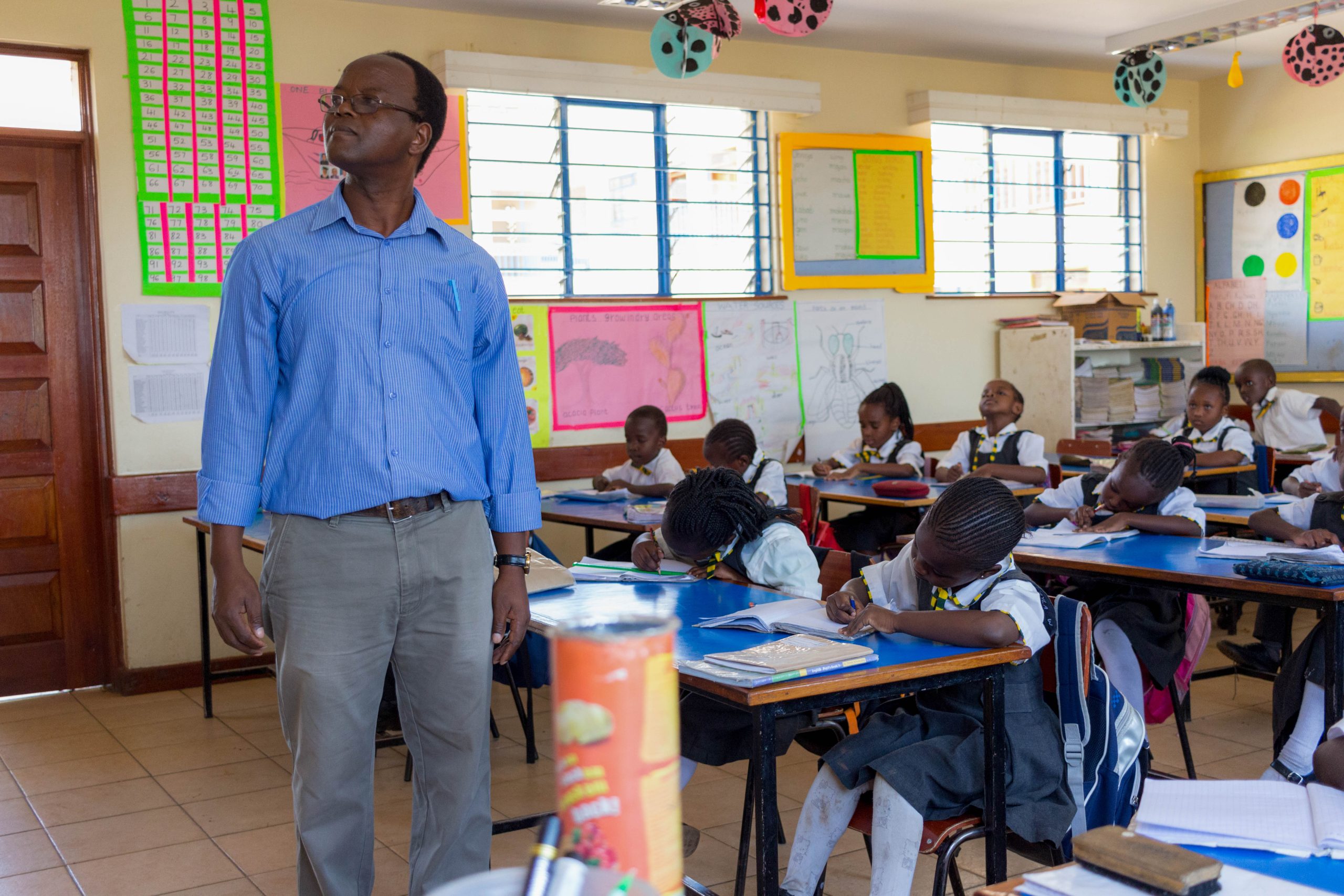 2017-Henry-Kamande-teaching-students-in-a-classroom-at-Urafiki-Carovana-School